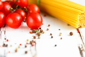 Cherry, onion, spaghetti, spices Ingredients for cooking pasta. Food background on a white table