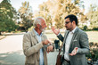 © bnenin - Young man explaining to dissatisfied senior man why he was late.