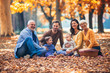 © Mediteraneo - Multl generation family in autumn park having fun