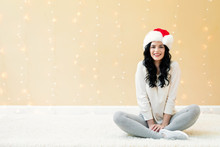 Happy Woman With A Santa Hat On A Shiny Light Background