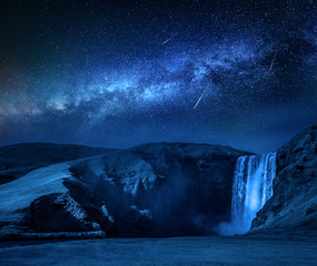 Wall Mural - milky way and falling stars over skogafoss waterfall in iceland