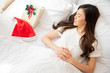 Young Asian woman sleep on the white bed when Christmas day with Santa hat and gift box on the bed