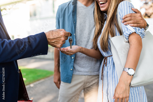 Fotografía Young happy couple talking with real estate agent and buying a new house