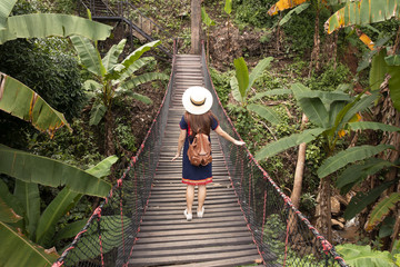 Sticker - A woman is entering to travel in the tropical jungle in Chiangmai, Thailand.
