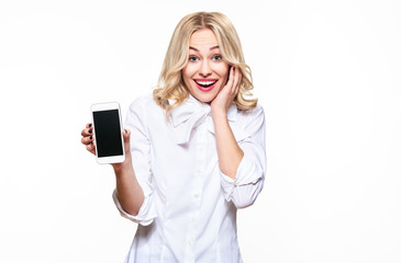 gorgeous excited woman showing blank screen mobile phone over white background, celebrating victory 
