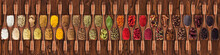 Spices And Herbs From Different Countries In Wooden Spoons. Colorful Seasonings On   Table Background, Top View.
