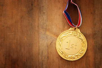 top view image of medal gold over wooden textured table.