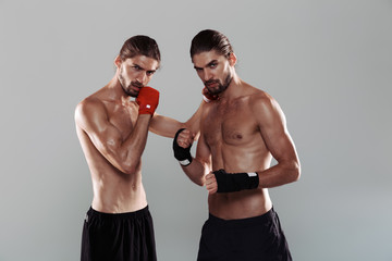 Portrait of a two attractive muscular shirtless twin brothers