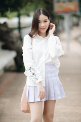 Wall Mural - portrait of asian girl with white shirt and skirt looking in outdoor nature vintage film style