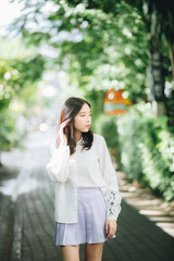 portrait of asian girl with white shirt and skirt looking in outdoor nature vintage film style