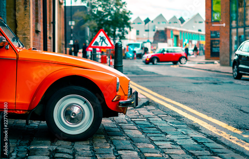 A Citroen Dyane Leaves A Parking Garage Driven By An Old Woman In