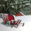A red Christmas sleigh in the snow.