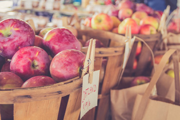 Fresh harvest apples attractively displayed in baskets at farmers market in vintage setting 