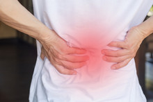 Man's Hands On His Back With Red Spot As Suffering On Backache. Male Person Sick From Lower Back Pain From Herniated Or Slipped Discs,Degenerative, Sacroiliac Joint, Spinal Stenosis, Pancreatic Cancer