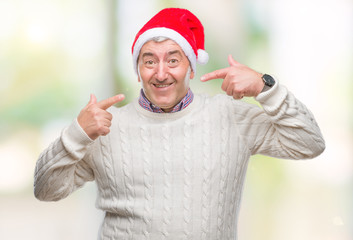 Wall Mural - Handsome senior man wearing christmas hat over isolated background smiling confident showing and pointing with fingers teeth and mouth. Health concept.