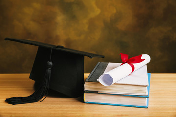 Wall Mural - Graduation concept.graduation cap, hat with degree paper on wood table.