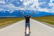 © lazurny - A msn stands on the highway in front of the mountains
