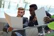 © ty - Bottom view. Two multinational young businessmen discussing at office during business meeting.