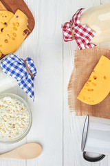 Wall Mural - Variety of dairy products, top view. Fresh milk, yogurt, cottage cheese and swiss cheese on wooden table. Vertical image with copy space.