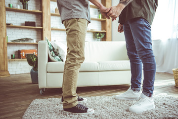 I am with you. Cropped portrait of two loving men standing together on fluffy carpet