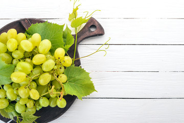 Wall Mural - Grape. Fresh white grapes on a white wooden background. Top view. Free space for text.