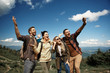 © Yakobchuk Olena - Two women and two men having fun during trip with rucksacks in highland. They standing jointly and laughing while gesturing happiness