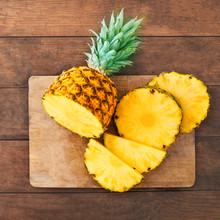 Pineapple On Wood Texture Background. Whole And Sliced Tropical Pineapple On Wooden Cutting Board  With Copy Space. Top View.