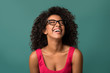 © Prostock-studio - Happy african-american woman laughing over blue background