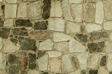 texture of a wall lined from stone boulders. architectural composition, part of the wall. decor