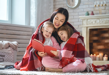 Wall Mural - mother reading a book to her daughters