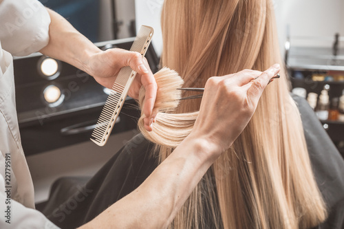 Cuadros en Lienzo Hairdresser is cutting long hair in hair salon
