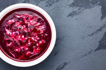 Wall Mural - Fresh homemade beetroot cream soup in bowl, photographed overhead on slate with copy space on the side (Selective Focus, Focus on the soup)