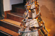 Steampunk christmas tree. Creative steel tree with metal ornaments and branches, stylish christmas decorations and garland lights in european city street. Festive decor, winter holidays