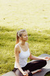© Olesia - Girl meditates while practicing yoga outdoors in park