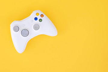 Gamepad is isolated on a yellow background. Gaming competition. White joystick on yellow background. Gamer concept. Controller for video games. Copyspace