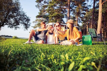 Wall Mural - Hipster friends by camper van at festival on a summers day.