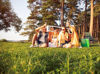 Wall Mural - Hipster friends by camper van at festival on a summers day.