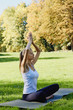 © Olesia - Girl meditates while practicing yoga outdoors in park