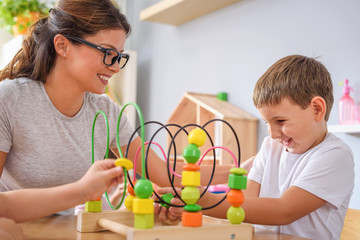 Wall Mural - Kindergarten Teacher and  Boy Playing With Bead roller coaster