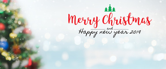 Christmas and Happy new year 2019 on blurred bokeh christmas tree banner background with snowfall.