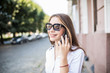 © F8  \ Suport Ukraine - Beautiful young woman in sunglasses using her cell phone on the summer street