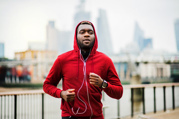 Poster - Young sporty black man runner running on the bridge outside in a city.