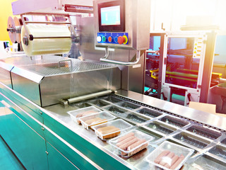 Wall Mural - Plastic containers with sausages on conveyor at food factory