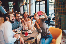 Group Of Happy Friends Having Making Selfie In Cafe