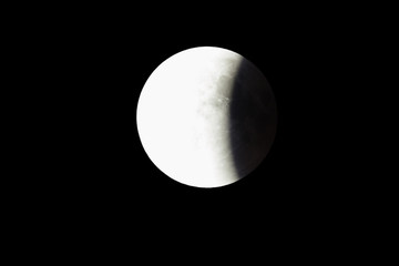 Wall Mural - super bloody moon, full eclipse last phase against black sky background, one third of the moon surfa