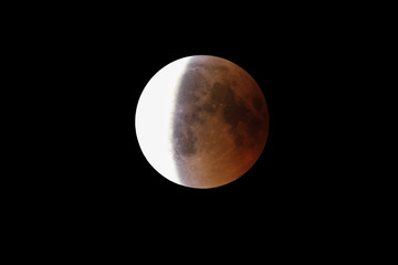 Wall Mural - super bloody moon, full eclipse end phase against black sky background, three-quarters of the moon s