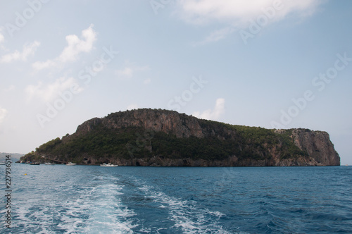 Fotografie, Obraz Isola in mezzo al mare e scia della barca. Calabria, Sud Italia.