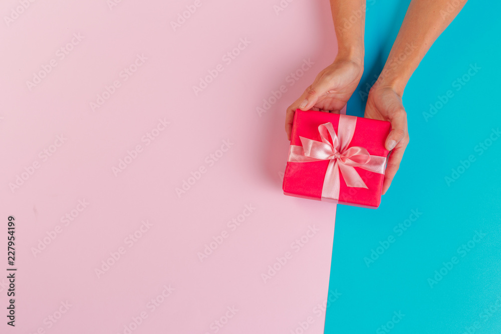 Obraz na płótnie Woman holding gift box on color background w salonie