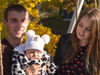 Smiling mother and father of a newborn baby . In autumn Park