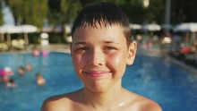  Portrait Of Cheery Small Brunet Boy Standing At The Edge Of A Swimming Pool With Trees Around A Lot Of Of People On A Sunny Day In Slow Motion